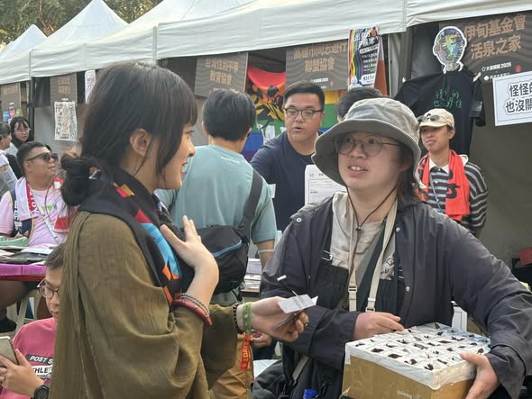 工作人員在戶外攤位與民眾交流障礙議題